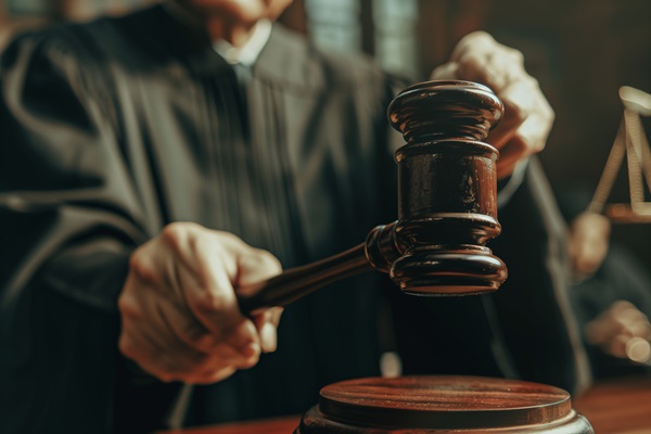 Judge in a courtroom striking a gavel on the bench, symbolizing a legal decision or sentencing during a trial.